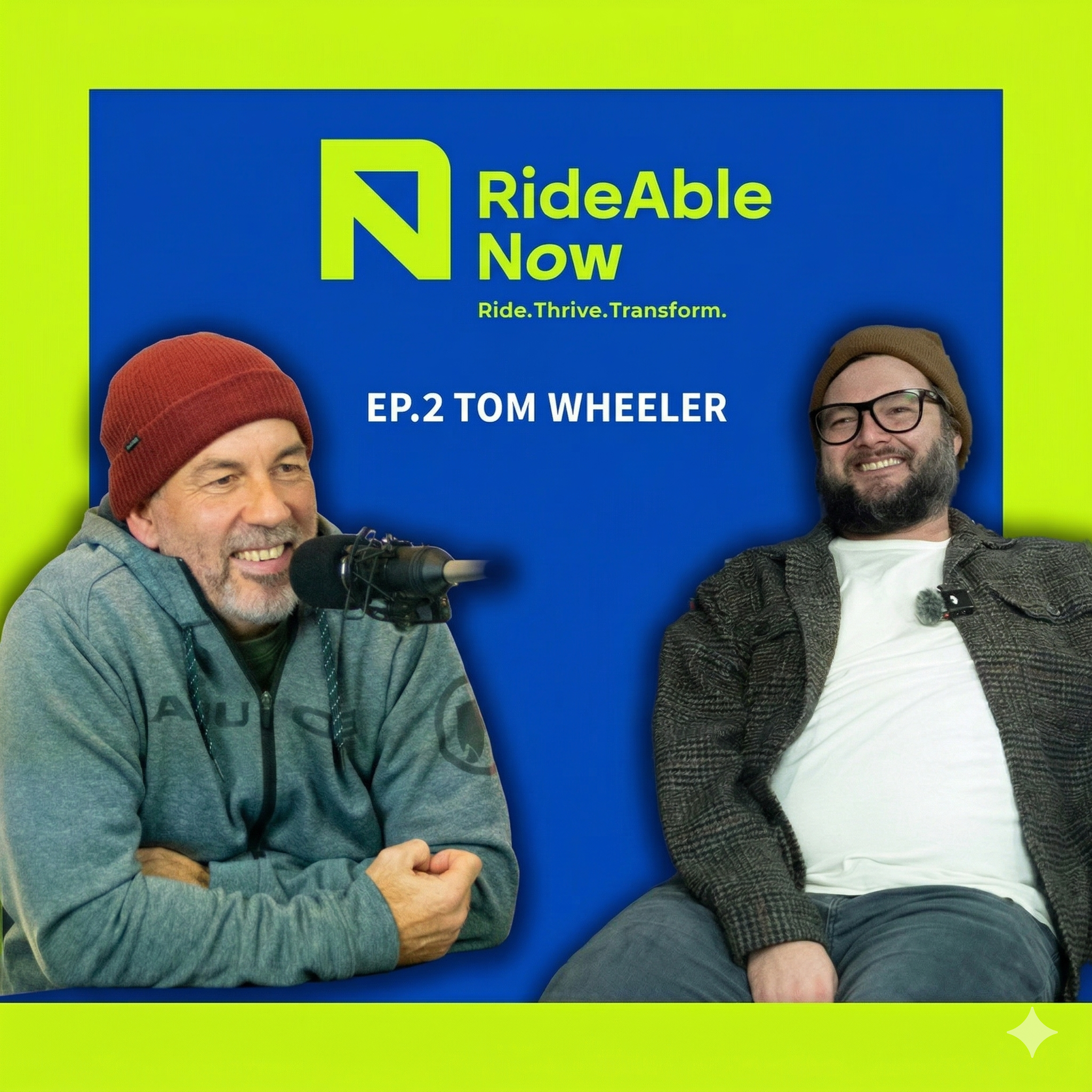 Two men sitting and smiling, one wearing a red beanie and hoodie with a microphone, the other wearing glasses, a brown beanie, and a jacket, in front of a blue background with green borders and text indicating a podcast episode about RideAble Now featuring Tom Wheeler.