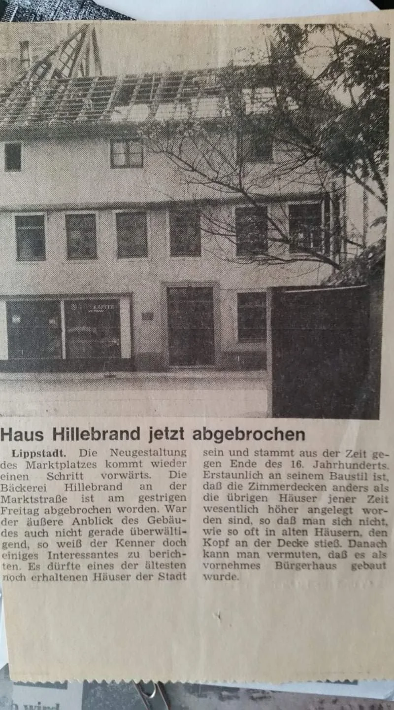 Schwarz-weiß-Foto eines alten, teilweise renovierten Hauses in Lipptstadt mit Baugerüsten auf dem Dach. Früher vermutlich ein Bürgerhaus, heute unvollständig renoviert.