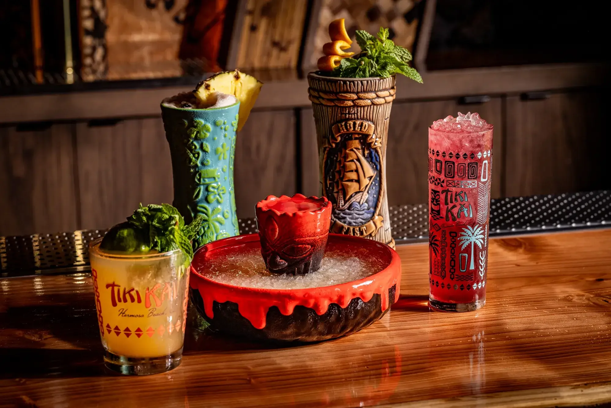 Collection of tropical cocktails in tiki mugs and glasses
