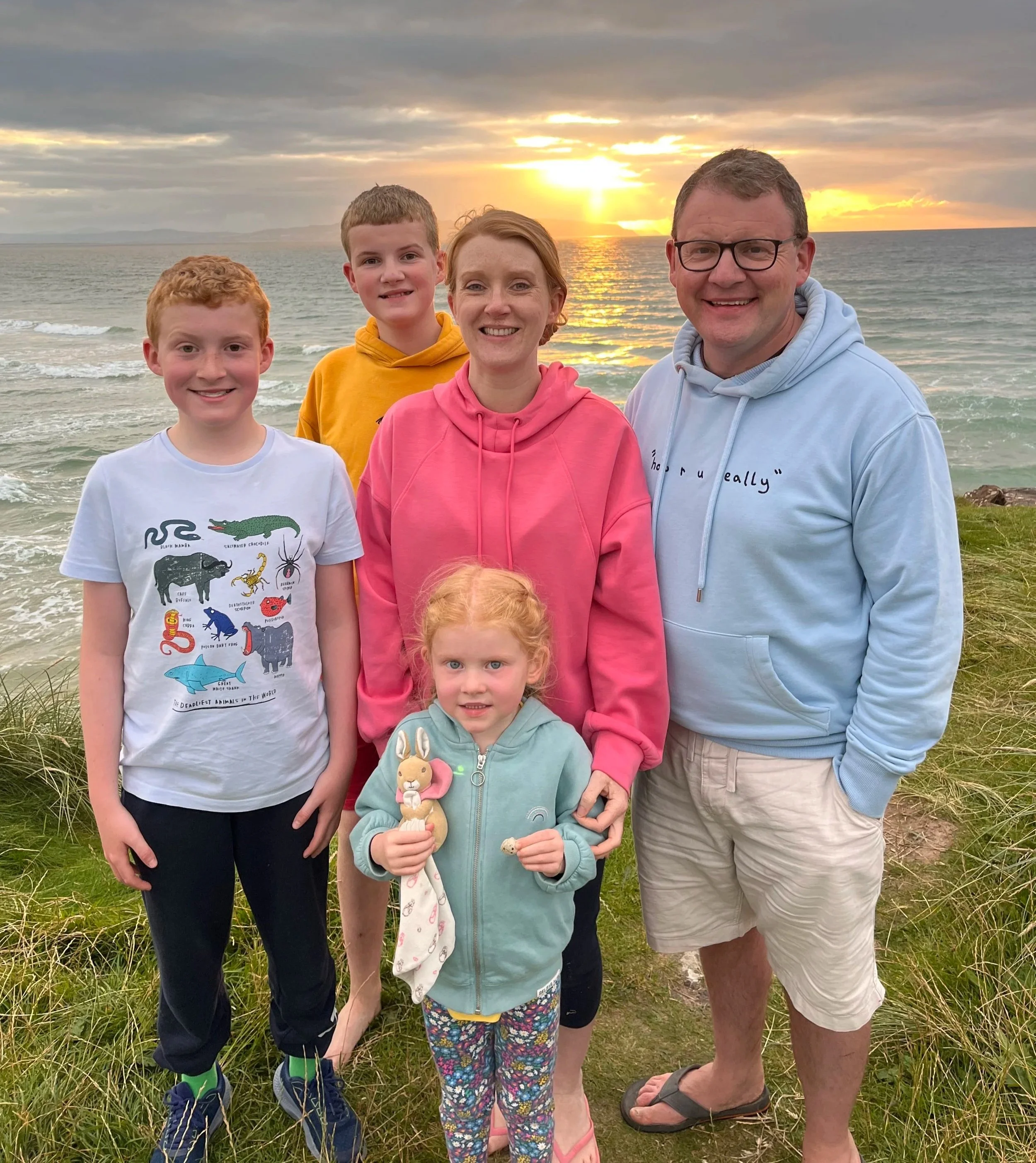 Minister Mark Johnston with his family on the cliffs overlooking the ocean.
