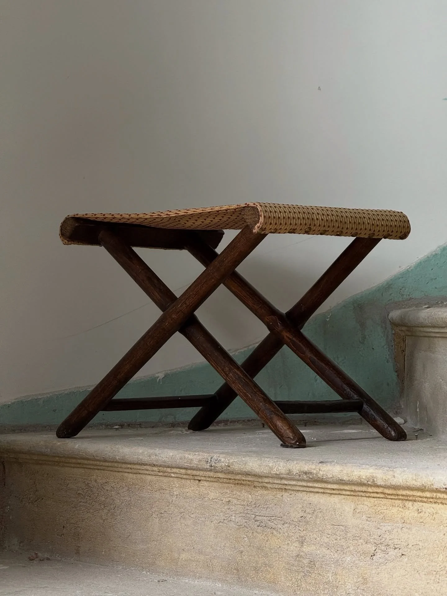 The Riviera Edit Highlight 🏷️
This vintage folding footstool balances form and function with a handwoven seat secured by delicate brass nails along its edge. The patina on the wood tells its story, while the thoughtful fold-away design makes it as p