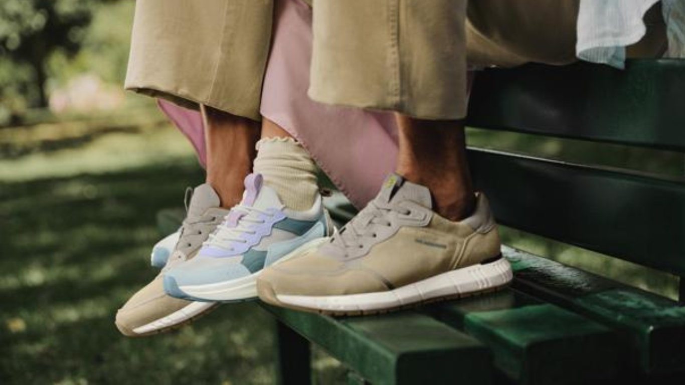 Personnes assises sur un banc dans un parc, inséparables chaussures de sport de couleurs différentes, dont une est bleu clair et l'autre beige.