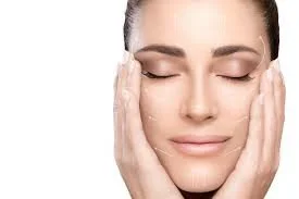 Close-up of a woman with closed eyes, touching her face gently with both hands.