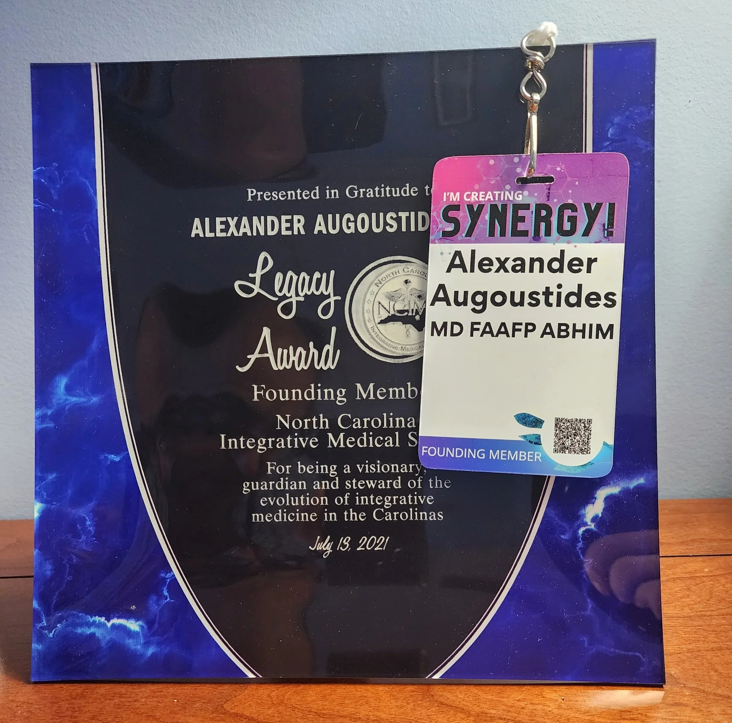 Honor plaque and attendee badge for Alexander Augustides, founding member of the North Carolina Integrative Medical Society, awarded on July 13, 2021.