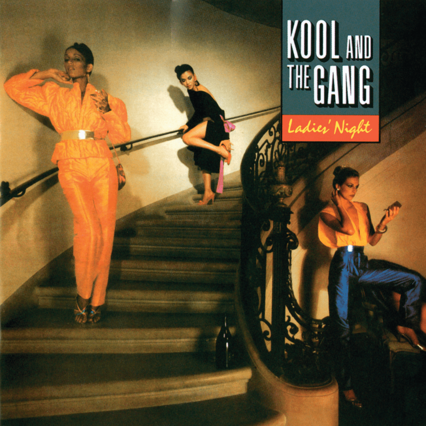 Three women on a staircase at a laser night event, with one in an orange jumpsuit, another in black and pink, and the third in yellow and blue, with a sign that says 'Kool and the Gang Ladies' Night'.