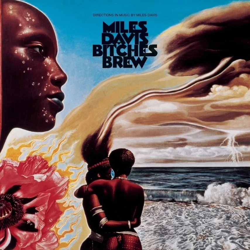 Album cover for 'Bitches Brew' by Miles Davis featuring artistic imagery of two African couples embracing on a sandy beach near the ocean, a woman's face with water droplets on the left, and colorful clouds and stormy weather in the sky.