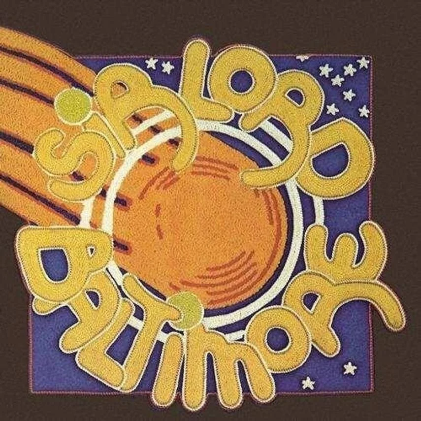 Colorful birthday card with a large orange circle in the center, surrounded by yellow text saying 'Happy Birthday' and a background with stars and stripes.
