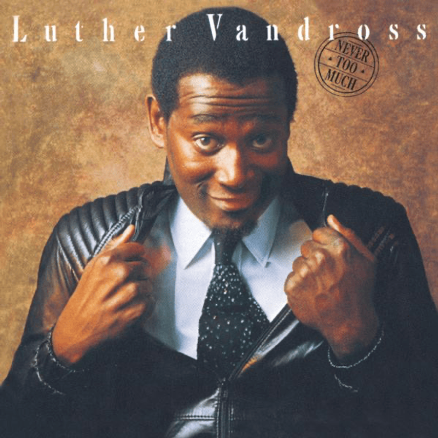 Album cover featuring Luther Vandross, dressed in a leather jacket, tie, and light blue shirt, adjusting his jacket and smiling, with the title 'Luther Vandross' and a stamp that reads 'Never Too Much' in the background.