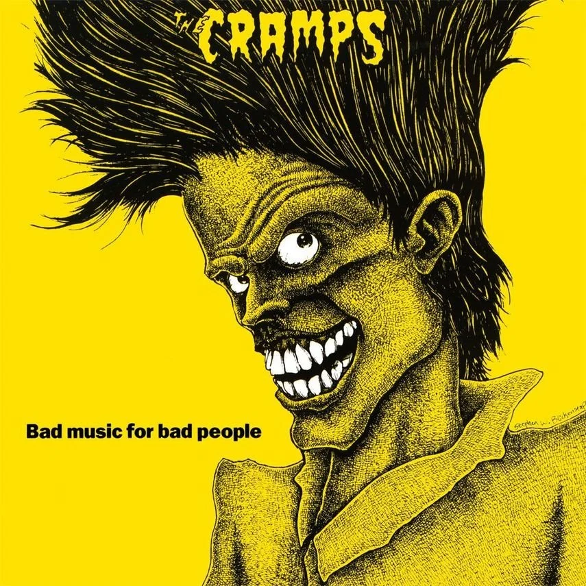 A cartoon-style illustration of a sinister character with a twisted smile, one distorted eye, wild hair, and yellow skin, set against a bright yellow background. The text 'THE CRAMPS' is at the top, and 'Bad music for bad people' is at the bottom.