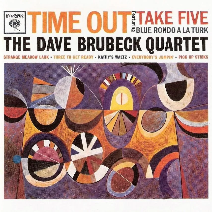 Album cover featuring abstract geometric artwork with circles, triangles, and lines in shades of purple, orange, yellow, black, and white, promoting a jazz album by The Dave Brubeck Quartet.