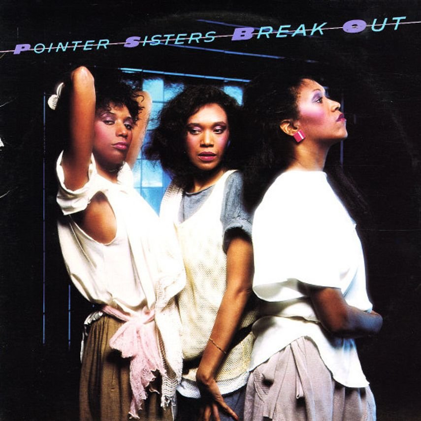 Three women standing in front of a dark wall with the words 'Pointer Sisters Break Out' written above. The women are dressed in stylish clothing and have confident expressions.