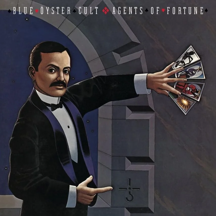 A man dressed in a tuxedo with a bow tie, pointing at a slot machine with his right hand and holding a fan of four cards with his left hand. The background has a dark, starry night sky with text that reads 'Blue Öyster Cult - Agents of Fortune' at the top.