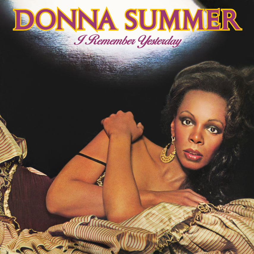Album cover of Donna Summer's 'I Remember Yesterday' featuring a woman lying down, with dark curly hair, gold earrings, and a colorful flowy fabric, with the artist's name and album title at the top.