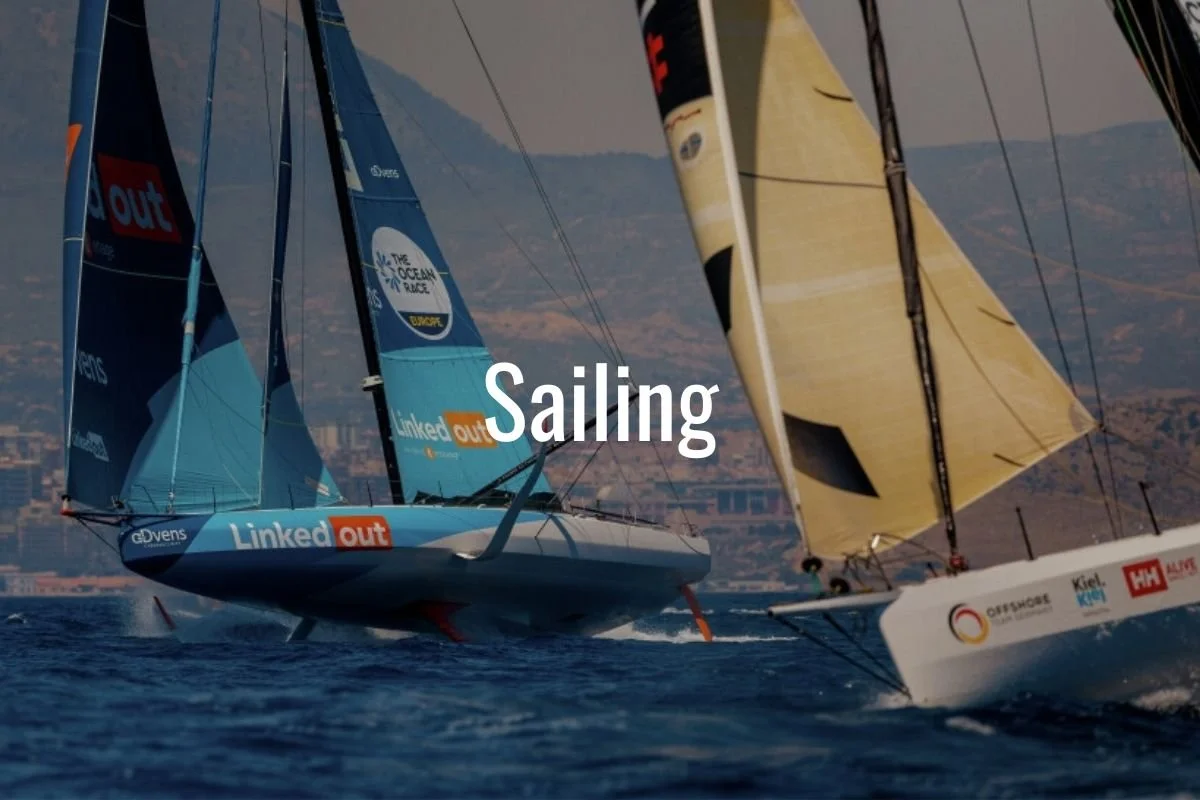Sailboats racing on the water with mountainous background and brown hills