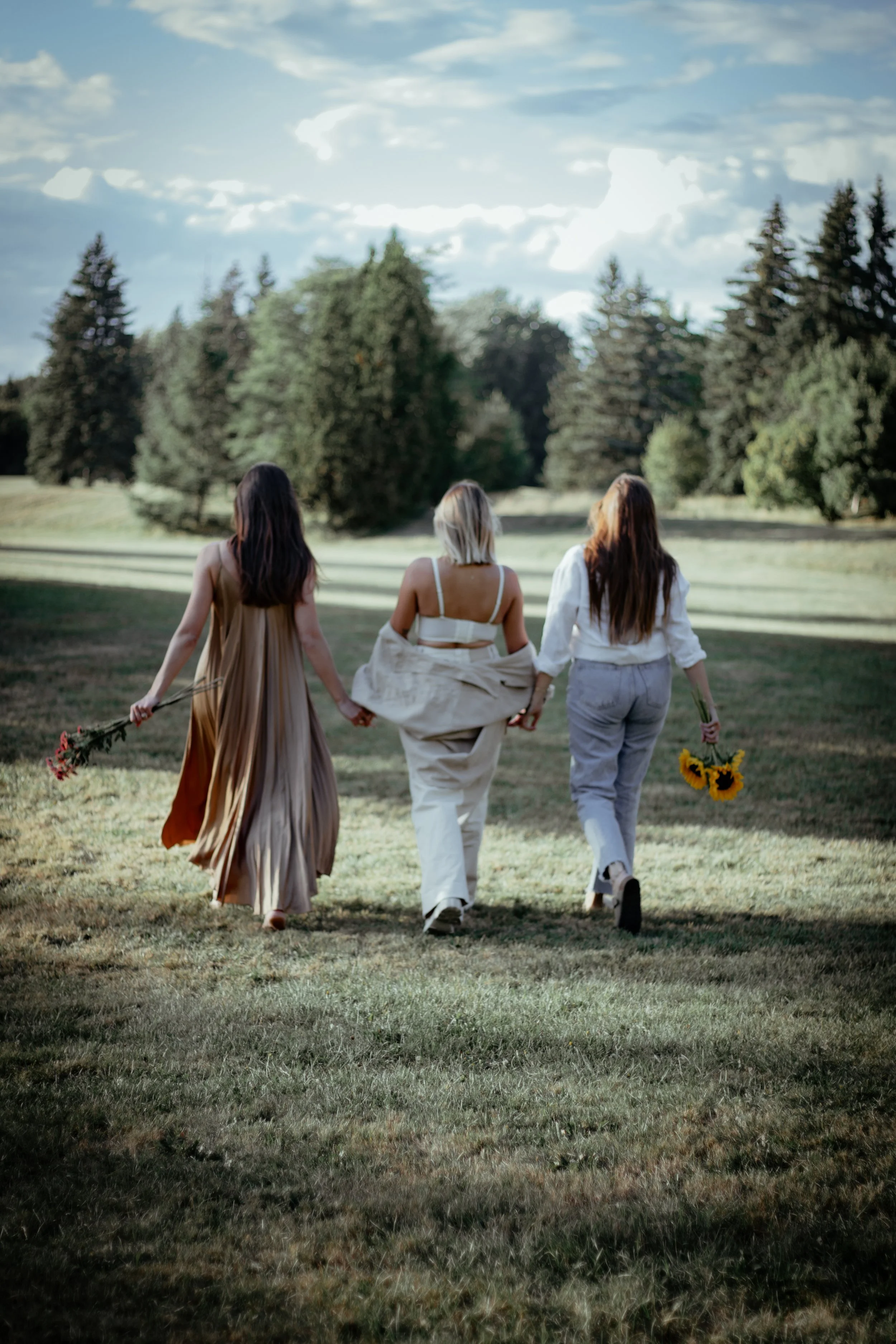 Photo de Trois amies femme qui marche main dans main au Parc Maisonneuve à Montreal