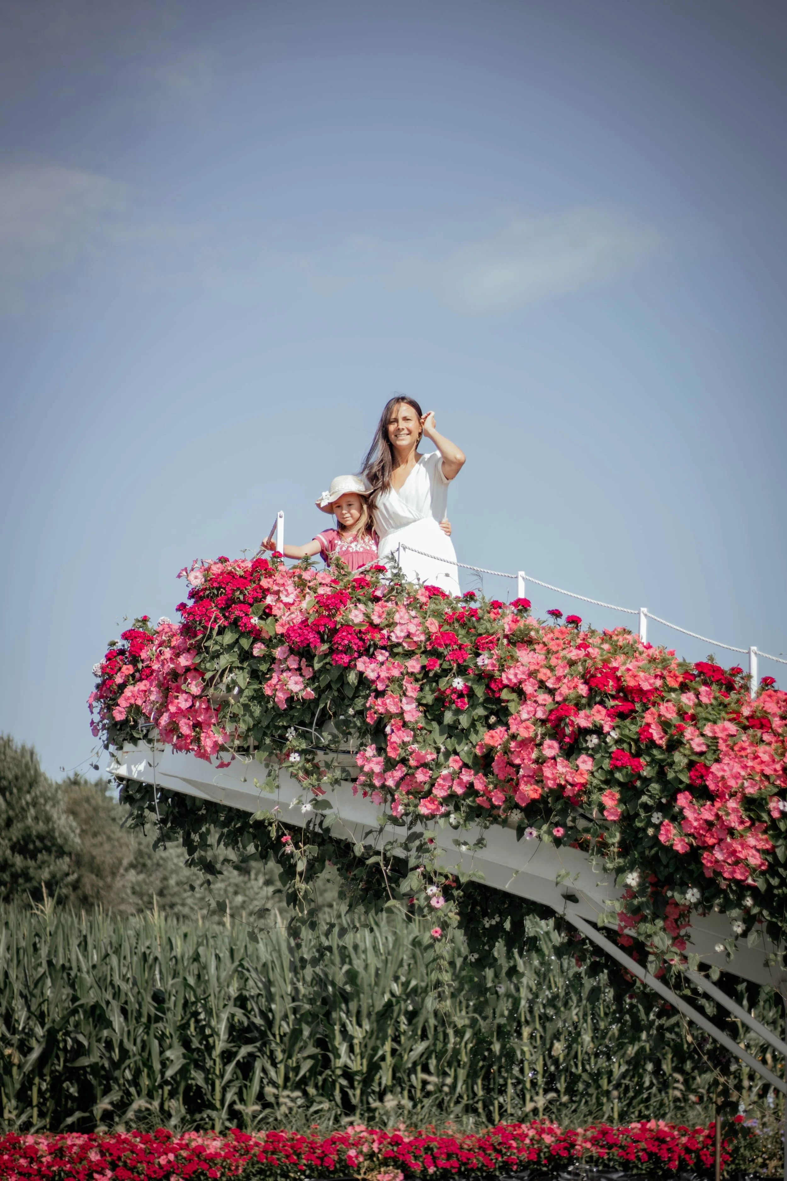 Protrait d'une maman et sa fille en haut d'une passerelle fleurie