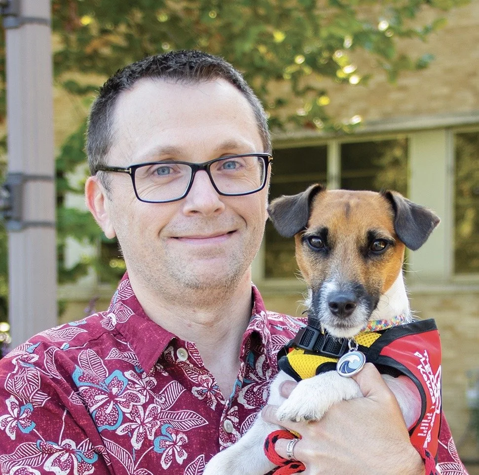 Dr. Jedediah Bragg holding his Jack Russell Terrier Koa and smiling