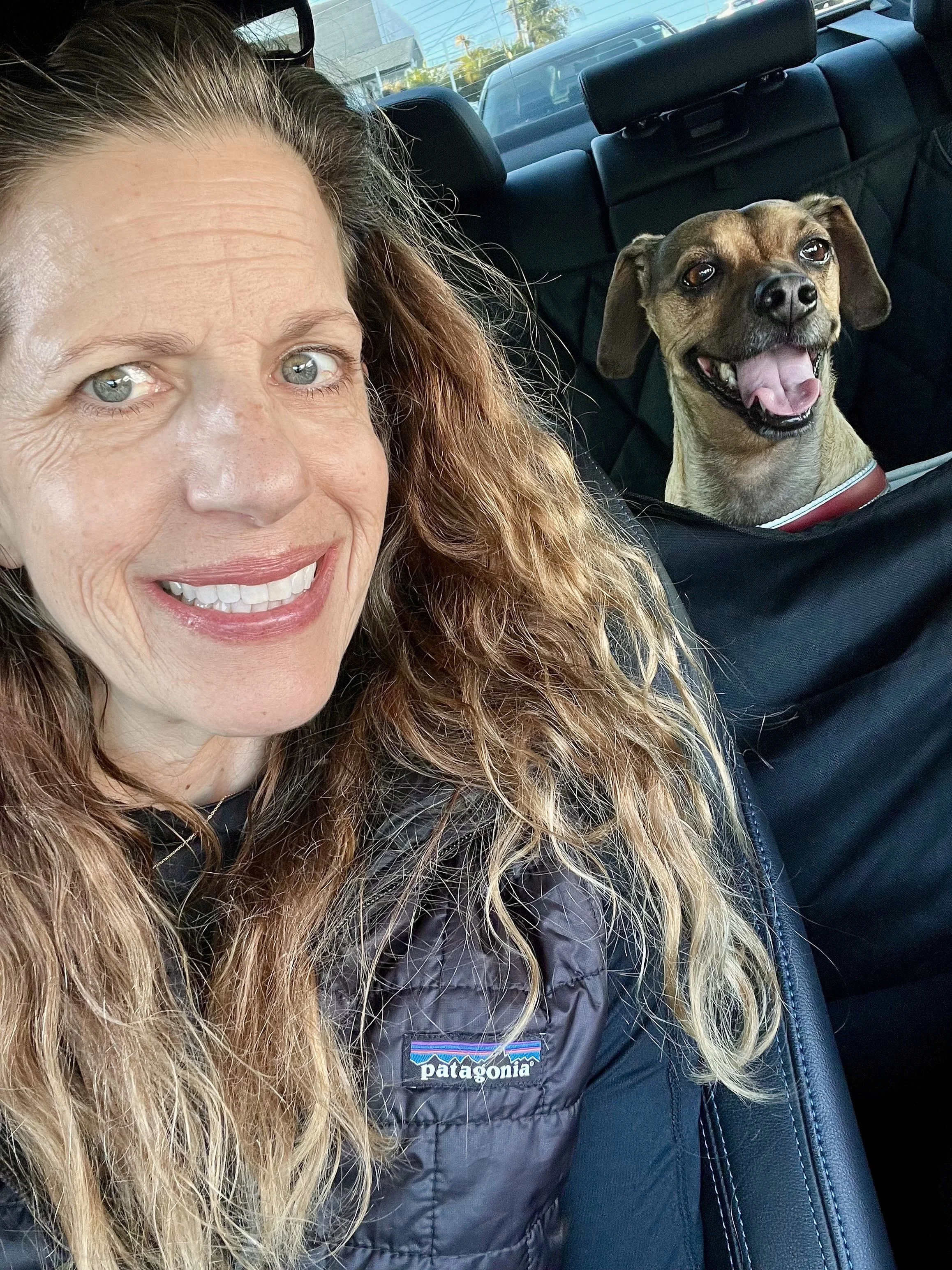 Denise St. Jean and her pet dog Jimbo smiling in car