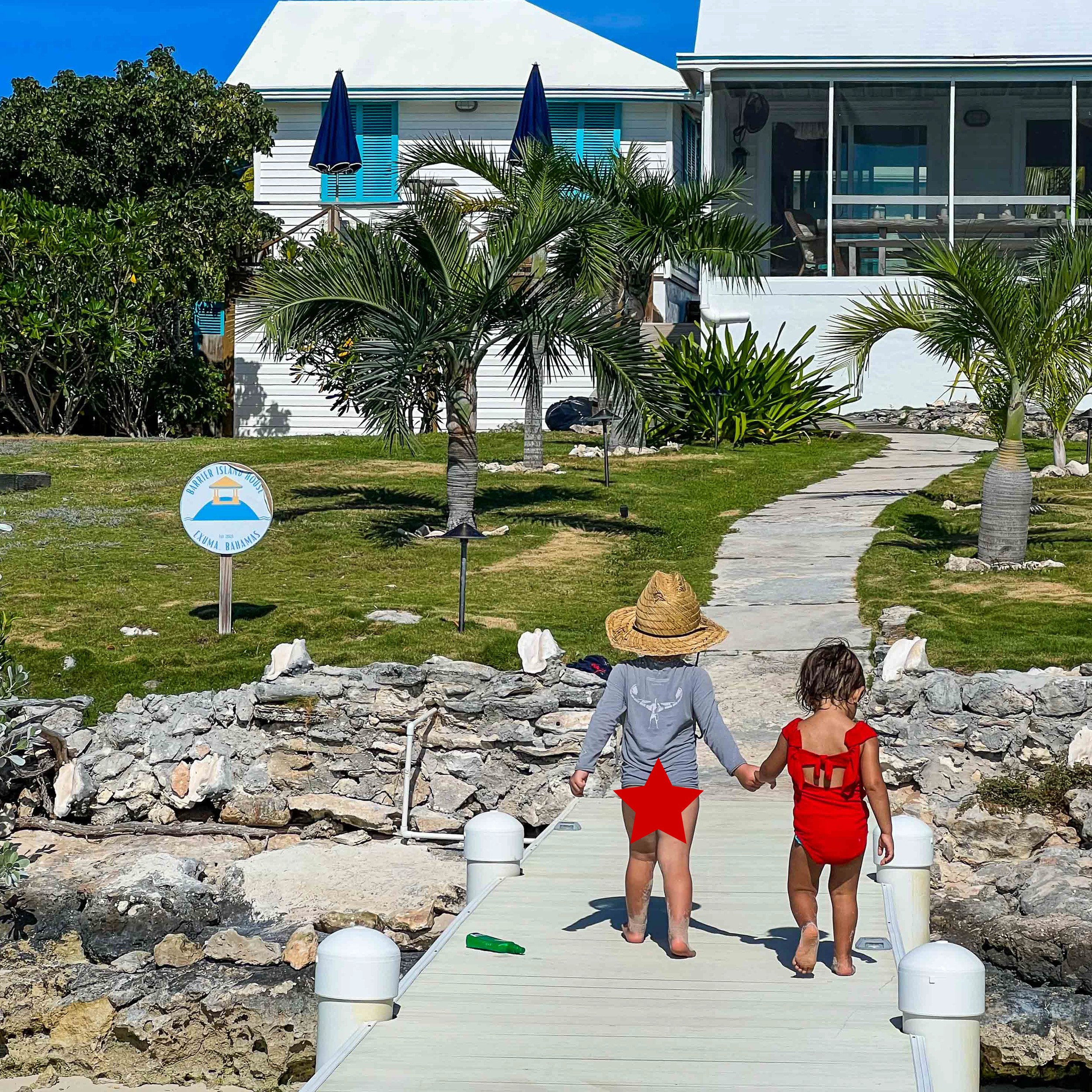 Two sisters hold hands as they walk on a dock at Barrier Island House