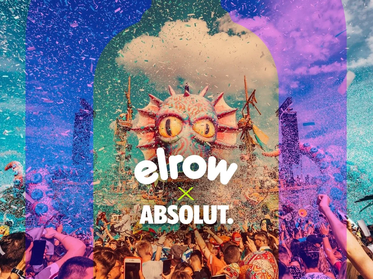 A festival scene with a large, colorful dragon-like puppet and a crowd of people celebrating, with confetti in the air and a cloudy sky in the background.