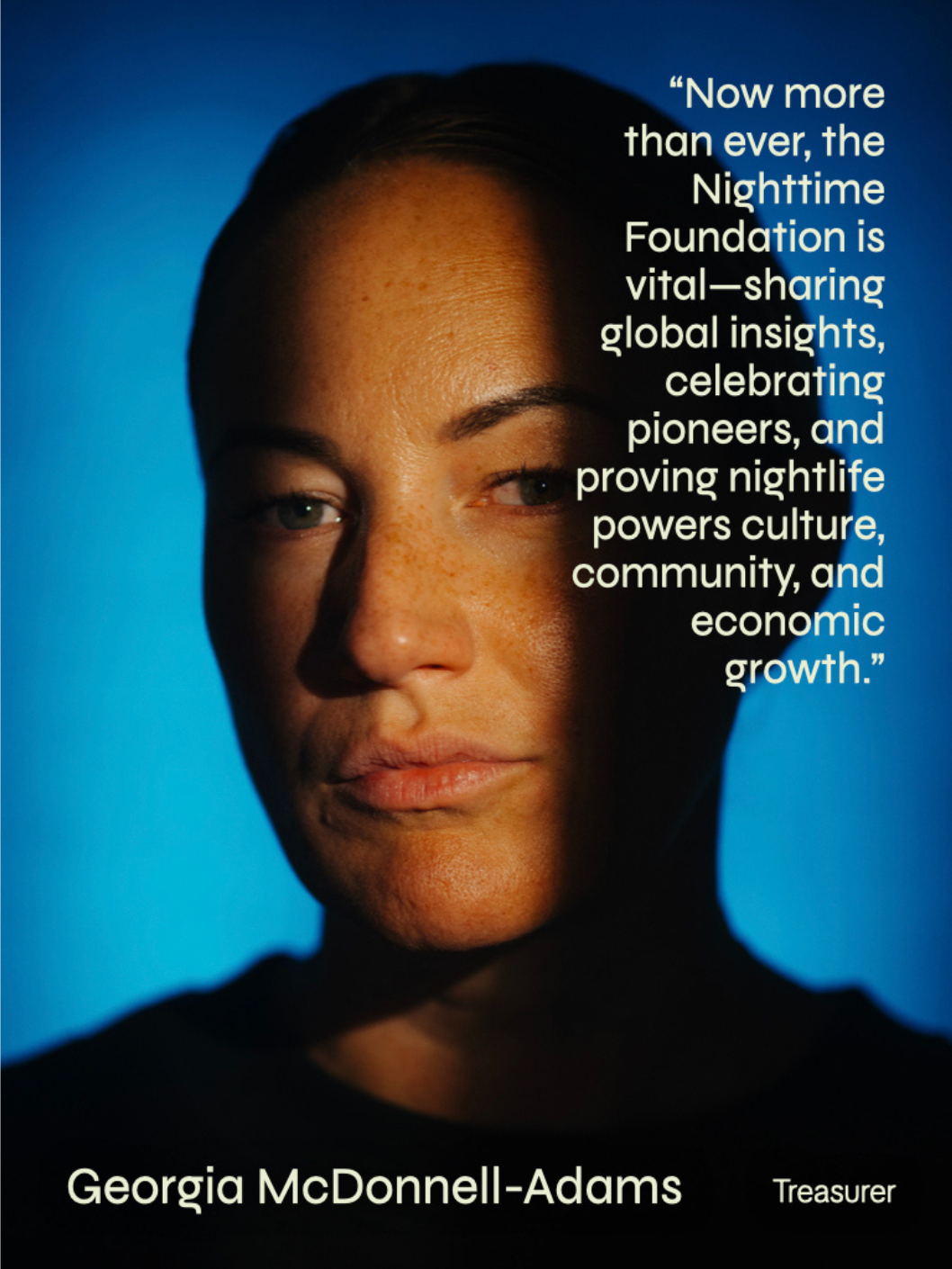 Close-up portrait of a woman with short hair, freckles, and light-colored eyes against a blue background, with overlaid text about the Nighttime Foundation's impact, and the name Georgia McDonnell-Adams labeled as Treasurer.