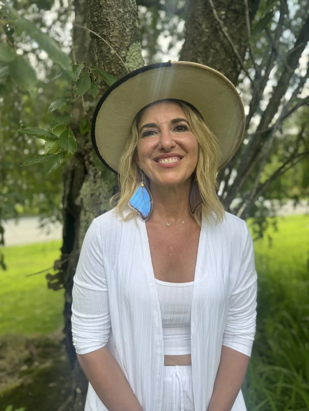 Rebecca Sharzer smiling in a wide-brimmed hat