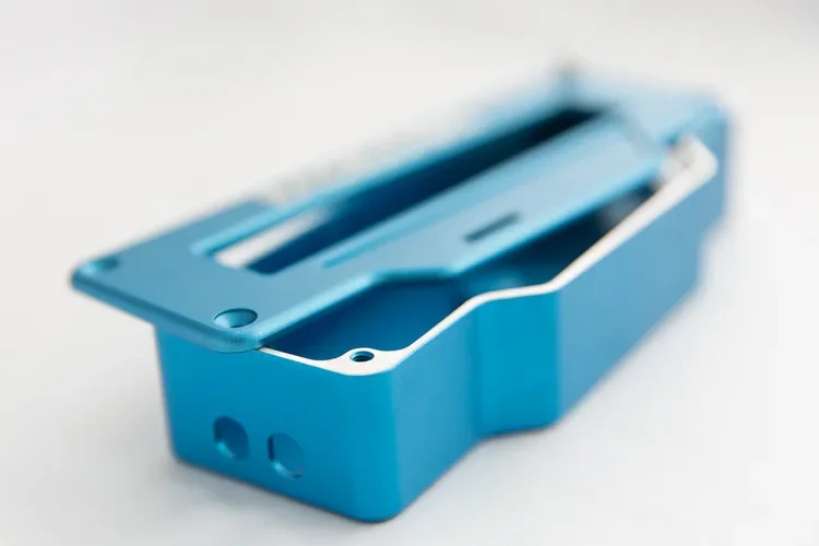 A blue plastic electronic device enclosure with a rectangular opening and mounting holes.