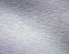 Blurred, textured surface with gradient shades of gray and white.
