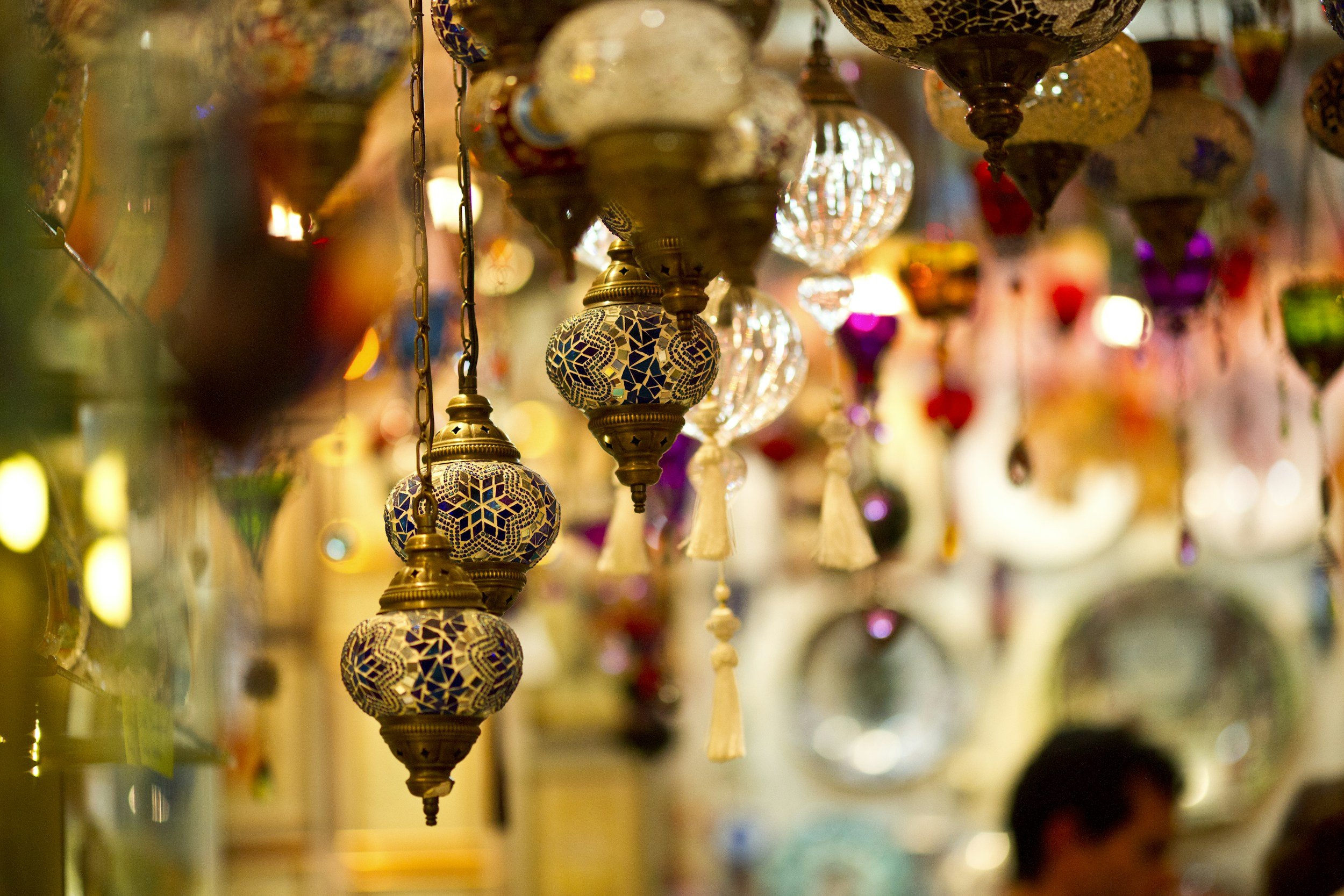 Colorful hanging Moroccan-style mosaic lanterns and glass ornaments in a decorated shop interior.