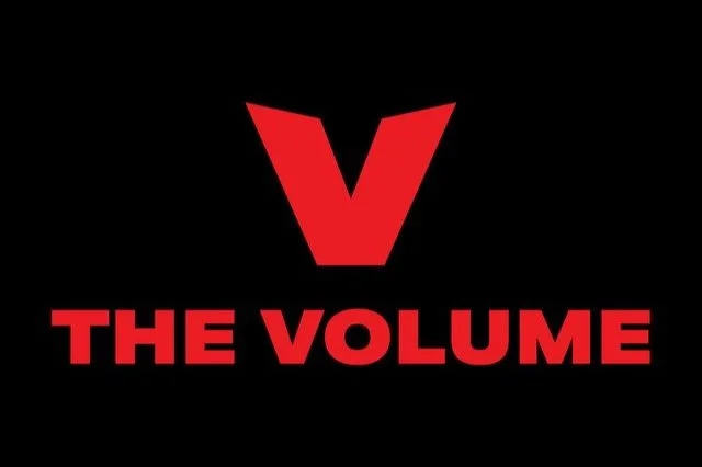 Red letter V above the text 'THE VOLUME' on a black background.