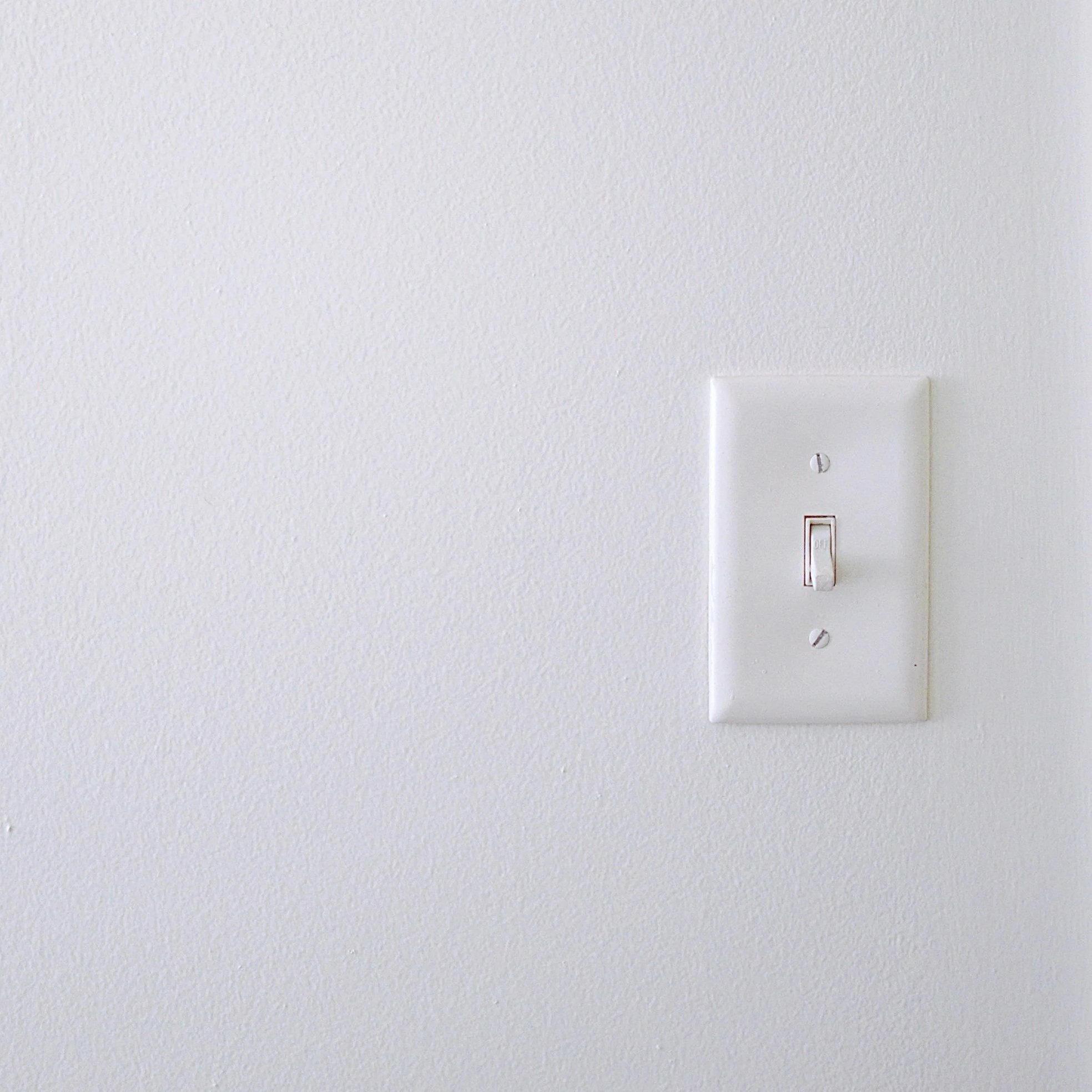 A damaged electrical light switch with visible scorch marks, representing dangerous arcing and potential fire hazards in homes.
