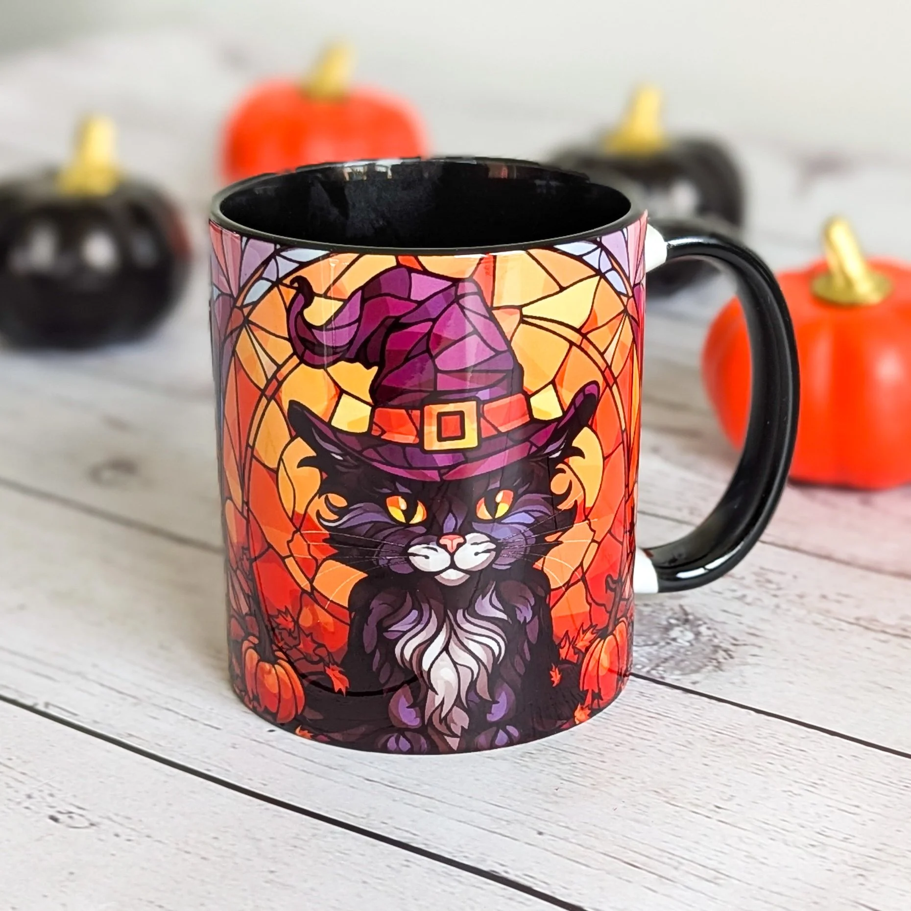 Halloween ceramic mug with black cat in a witch hat, glowing eyes, pumpkins, and autumn background, black handle and interior.