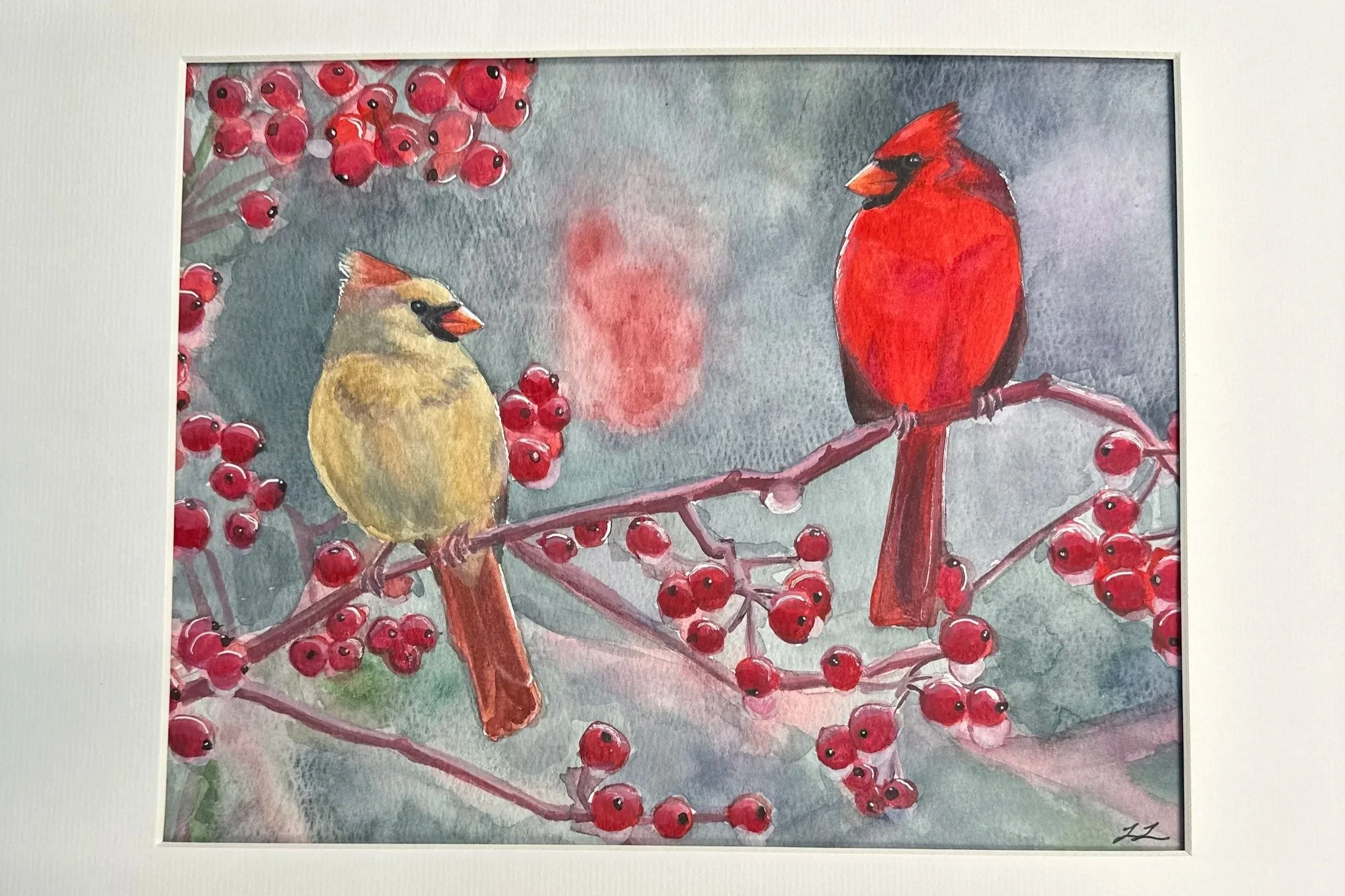 Watercolor painting depicting two cardinals, one yellowish and one bright red, perched on a branch surrounded by red berries, with a grayish background.