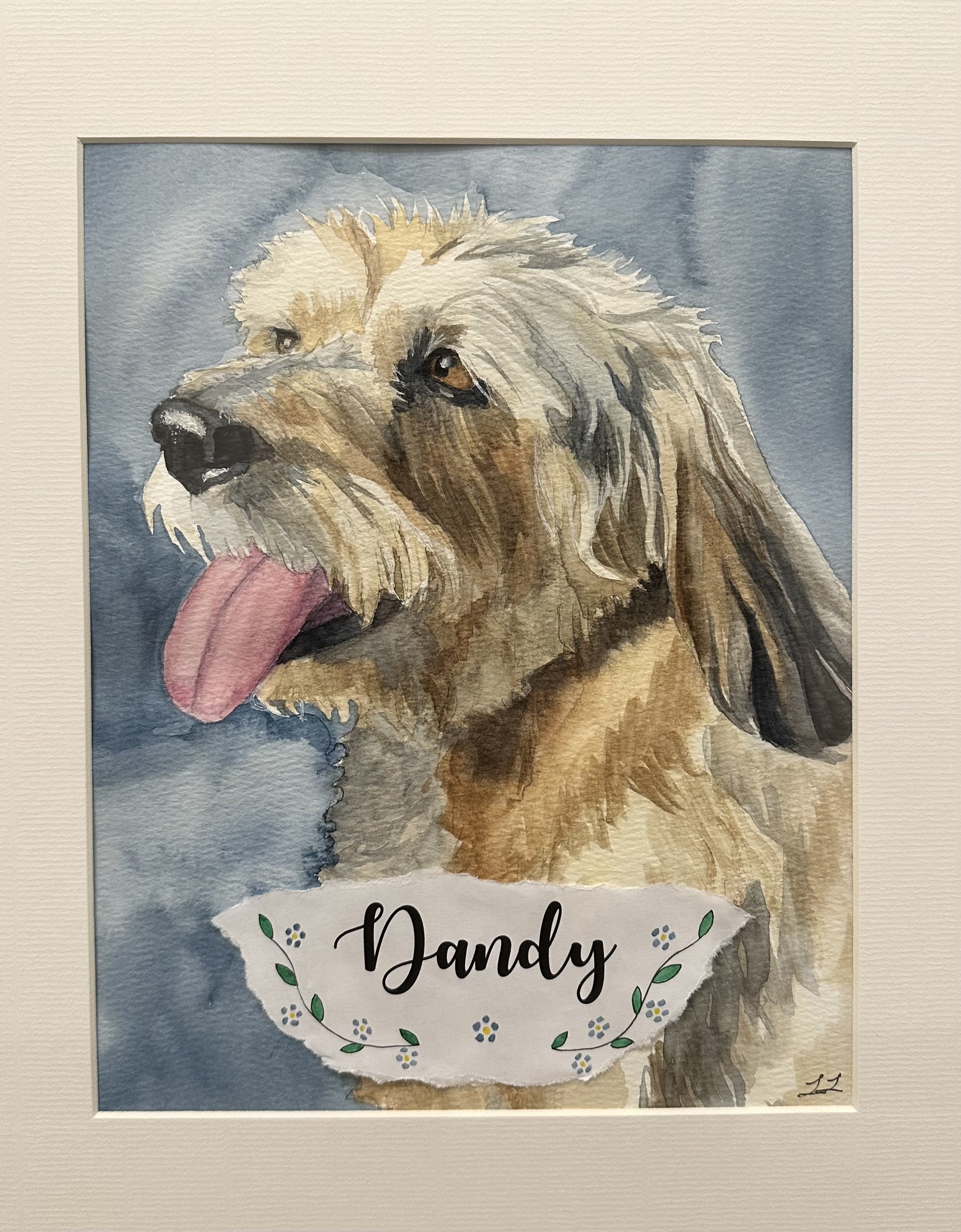 Watercolor painting of a golden retriever dog with its tongue hanging out, framed with a white mat and a label that says 'Dandy' with small floral decorations.