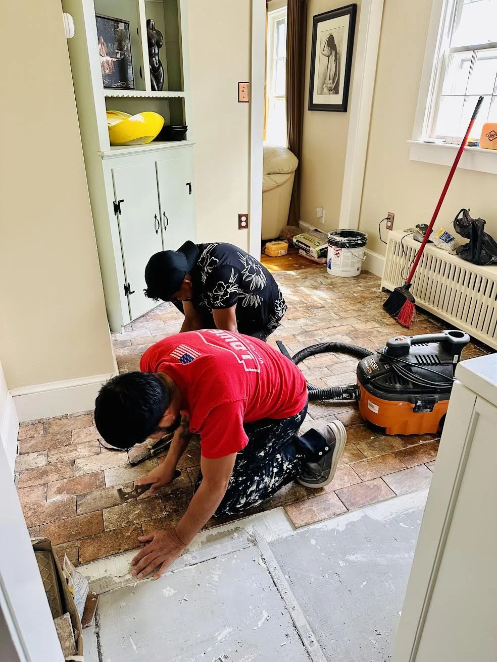 Many and partner installing grout