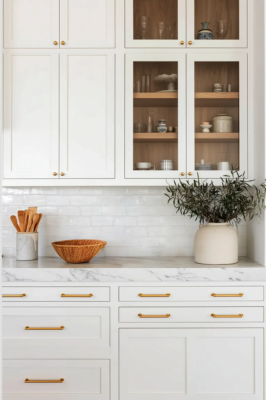 Ivory kitchen cabinetry with marble countertop and warm brass hardware from Studio 51 project in Bucharest, designed by Studio Sakaia.