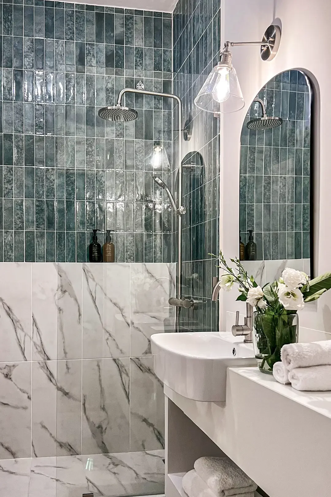 Modern bathroom by Studio Sakaia featuring green tiled shower, marble walls, and minimalist rectangular sink.