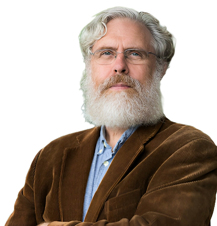 An older man with white hair and a white beard, wearing glasses, a blue button-up shirt, and a brown jacket, standing with arms crossed against a plain background.