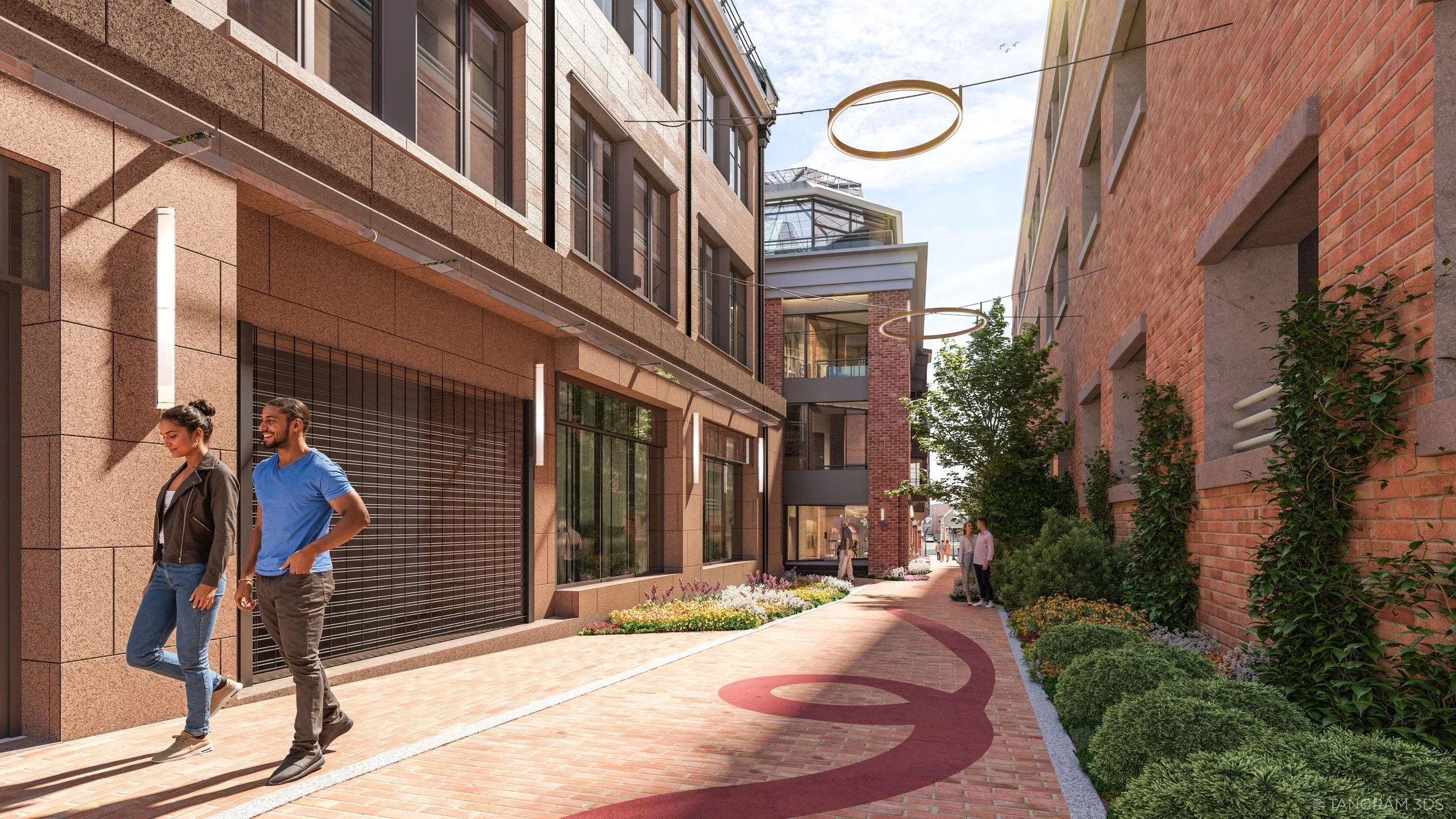Modern urban street scene with pedestrians walking on a brick-paved sidewalk between buildings, some greenery, streetlights hanging above, and the sky visible overhead.