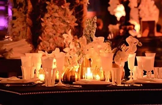 Elegant dinner table decorated with flowers and candles at night