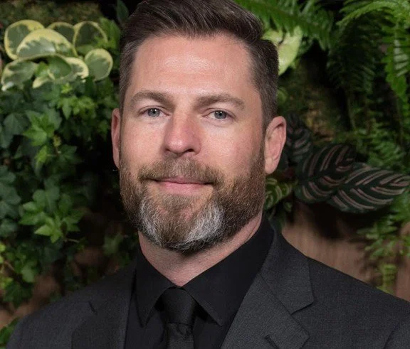 Head shot of Brian Goldstein in black suit