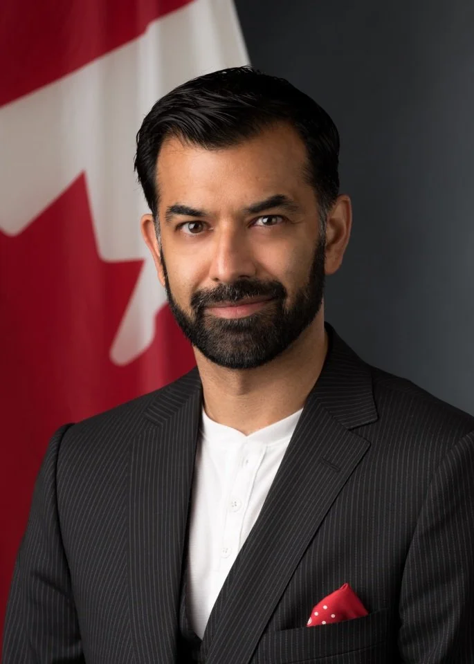 Headshot of Zaib Shaikh in front of Canadian flag