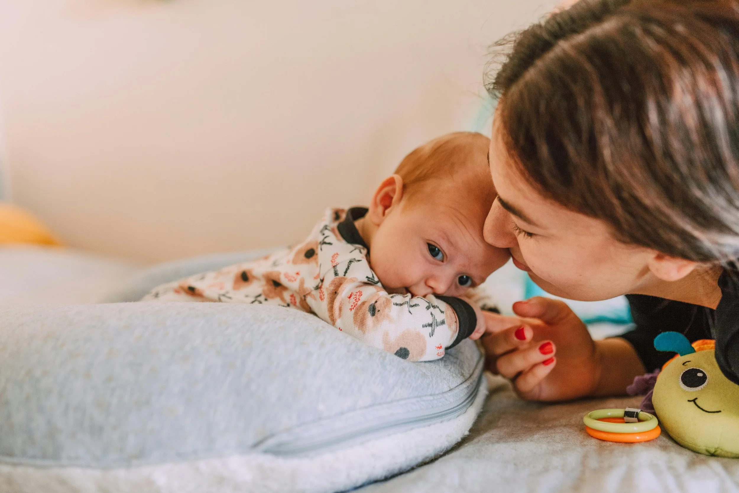 Mom and baby snuggling at Bloom Her Path where Groups, Classes, and Workshops are offered for mom and baby for infant development and feeding, breastfeeding, pelvic health, and more