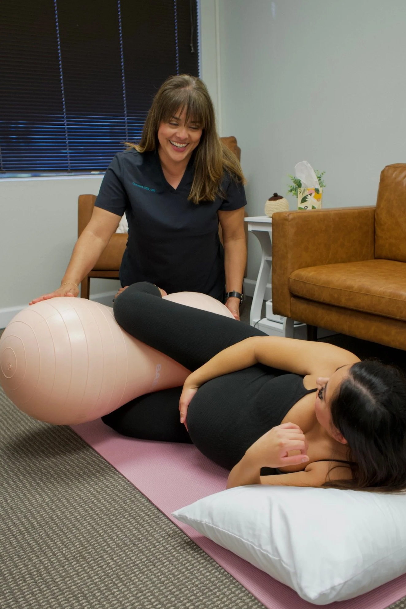 Christine Hernandez helps a patient with a peanut ball in a labor simulation to educate the patient on labor positions to optimize the pelvic floor and reduce perineal tearing and improve vaginal birth outcomes at Bloom Her Path in Corpus Christi, TX