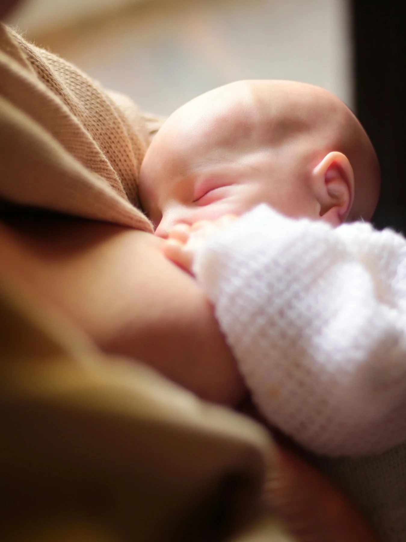 Breastfeeding infant on mother's breast at Bloom Her Path in Corpus Christi, TX we provide occupational therapy and certified breastfeeding specialists to address breastfeeding challenges like nipple pain, clicking at breast or bottle, supply issues