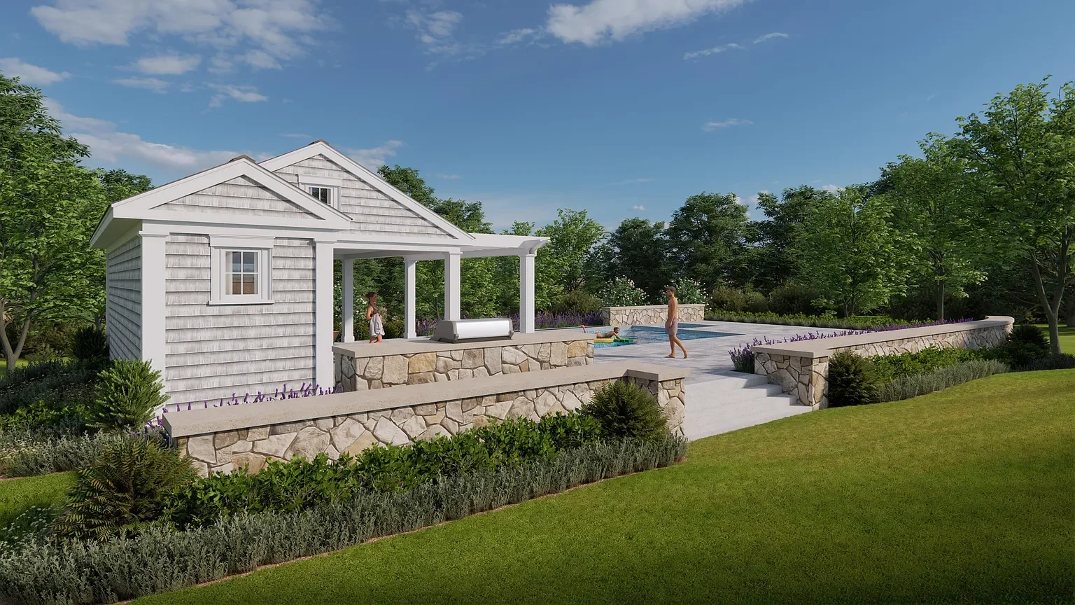 A backyard with a stone wall, concrete patio, small pool, and a house with gray siding, surrounded by trees and greenery under a blue sky.