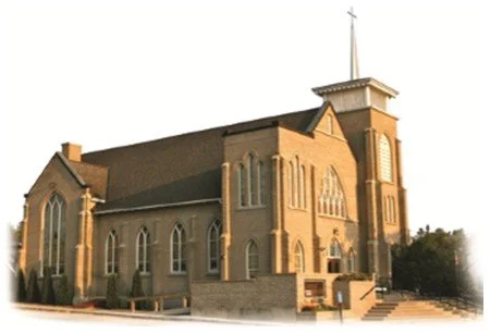 A large church with Gothic-style windows, a tall tower, and a brick exterior.
