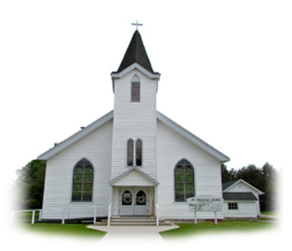 White church with a steeple and a cross on top, surrounded by green grass and trees.