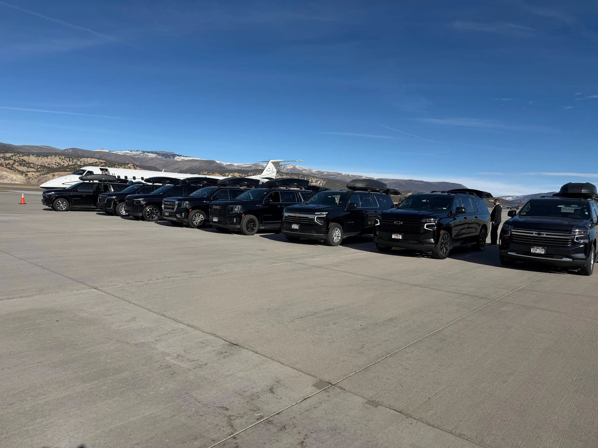 IZKAM fleet of black luxury SUVs at a private Colorado airport