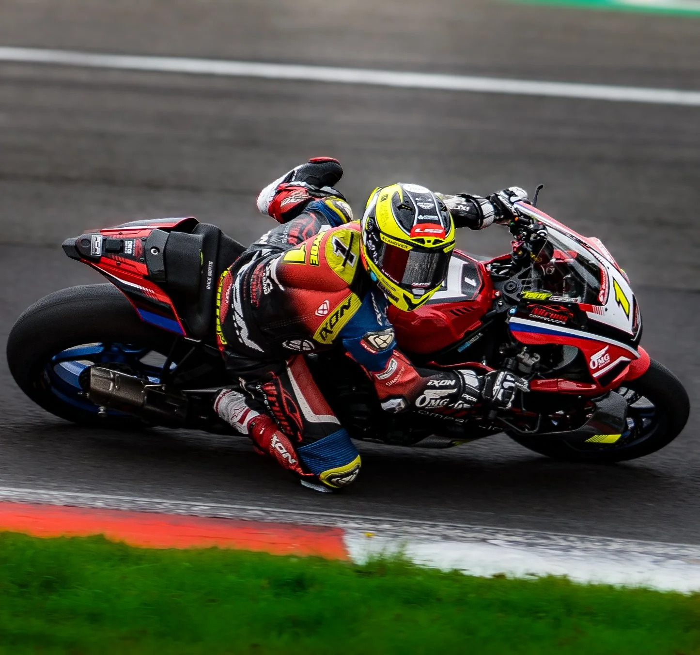 Motorcycle racer leaning into a turn on a racetrack.